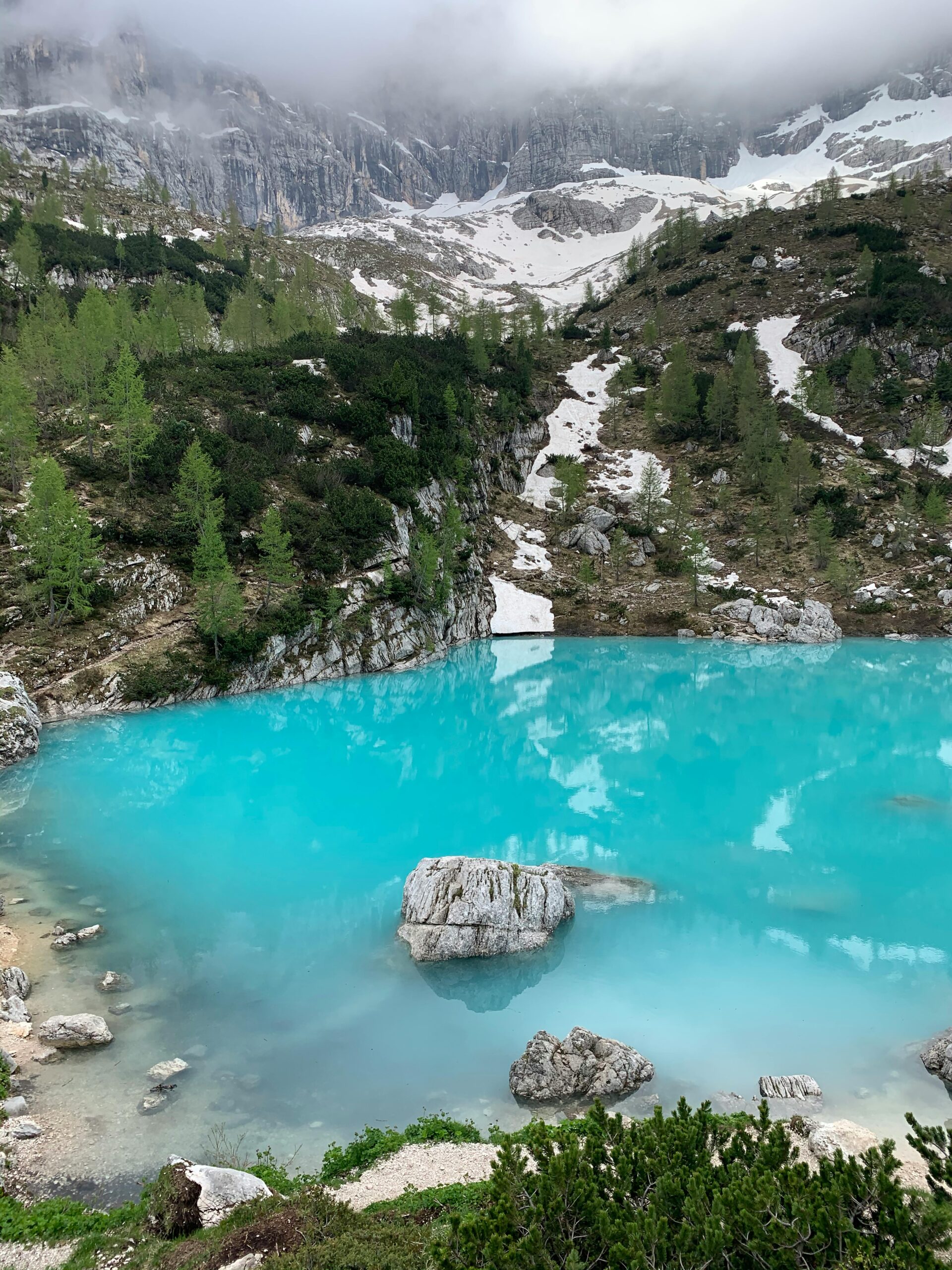 Pogled na turkizno jezero Lago di Sorapis obdano z rdečimi skalami Dolomitov